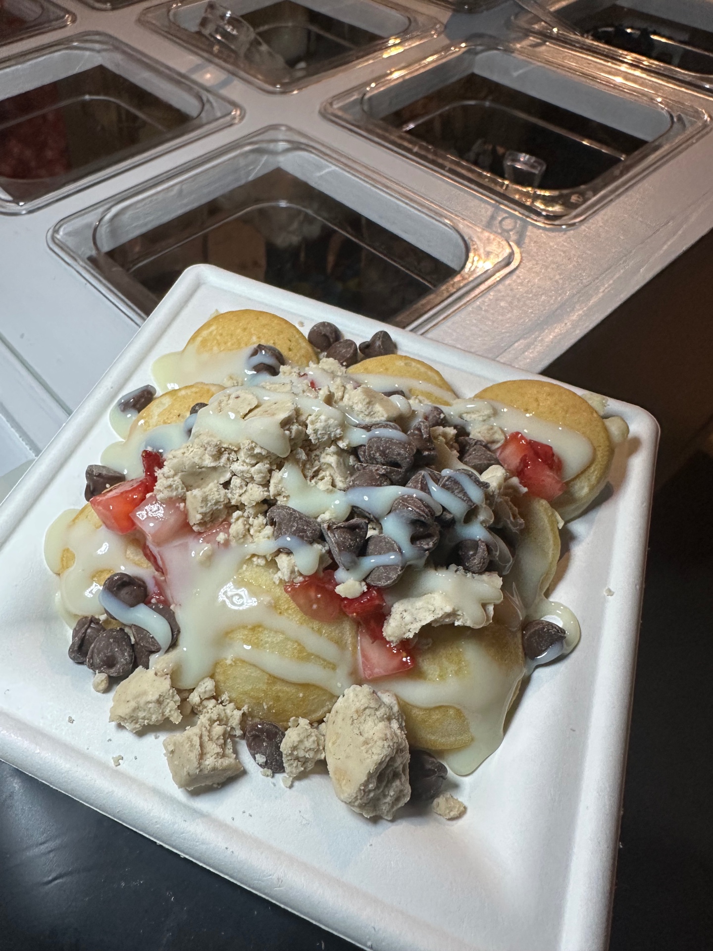 Mini pancakes topped with strawberries, chocolate chips, and cream