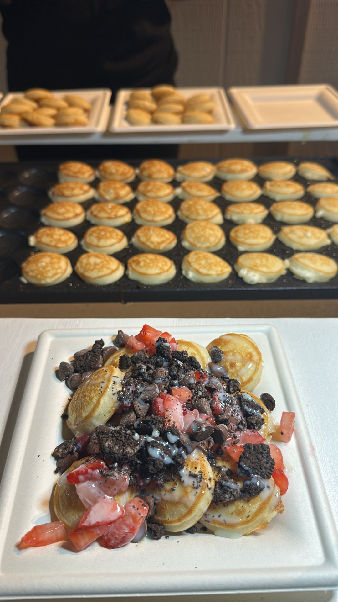 Mini pancakes topped with strawberries, chocolate, and cookie pieces