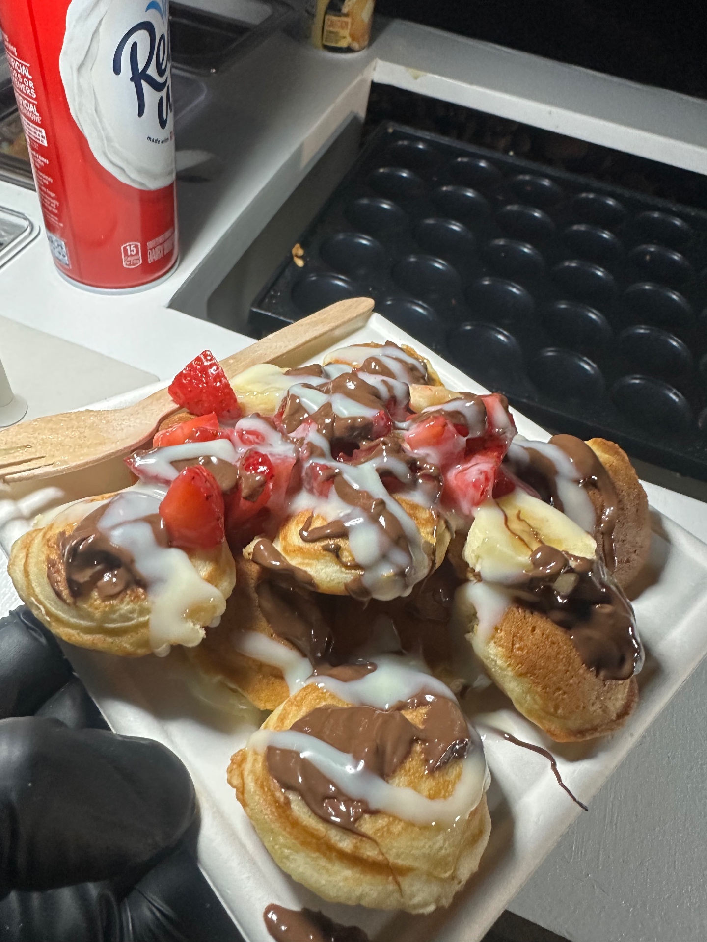 Mini pancakes topped with strawberries and chocolate drizzle