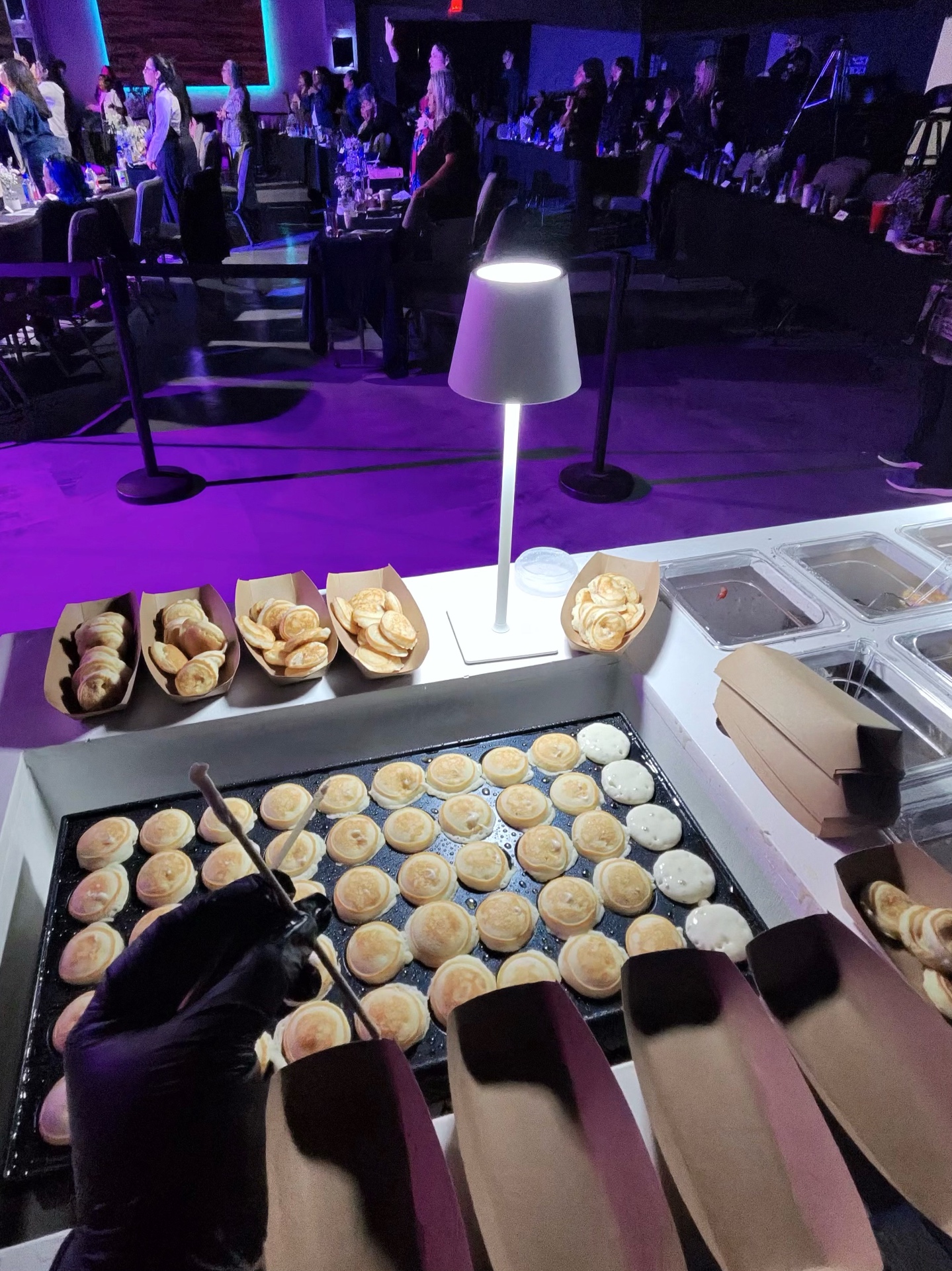 Mini pancakes cooking fresh on the griddle at an event