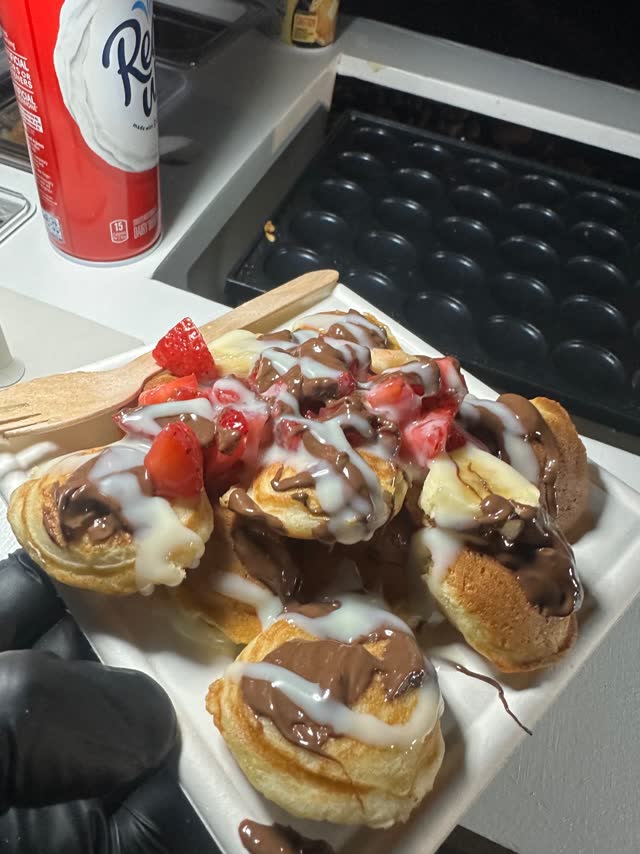 Mini pancakes topped with strawberries and chocolate drizzle
